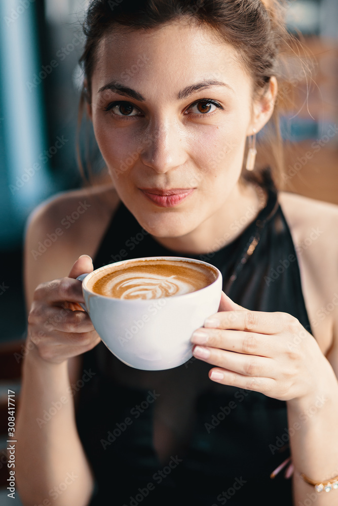 Refined Woman Enjoying Cappuccino or Latte on a vibrant, colorful background indoors. Refined Woman Enjoying Cappuccino or Latte on a vibrant, colorful background indoors.