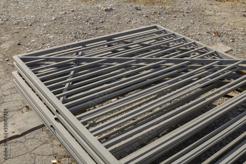 Manufactured metal fences, stacked and painted in gray.
