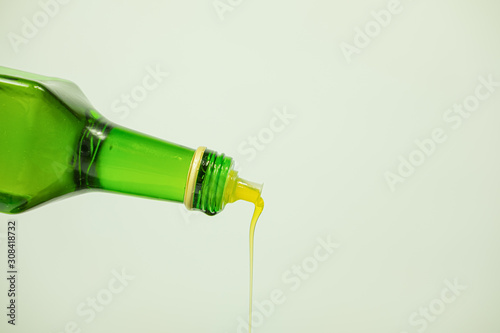 Oil pouring out of a glass bottle. Fine vegetable oil, close-up view