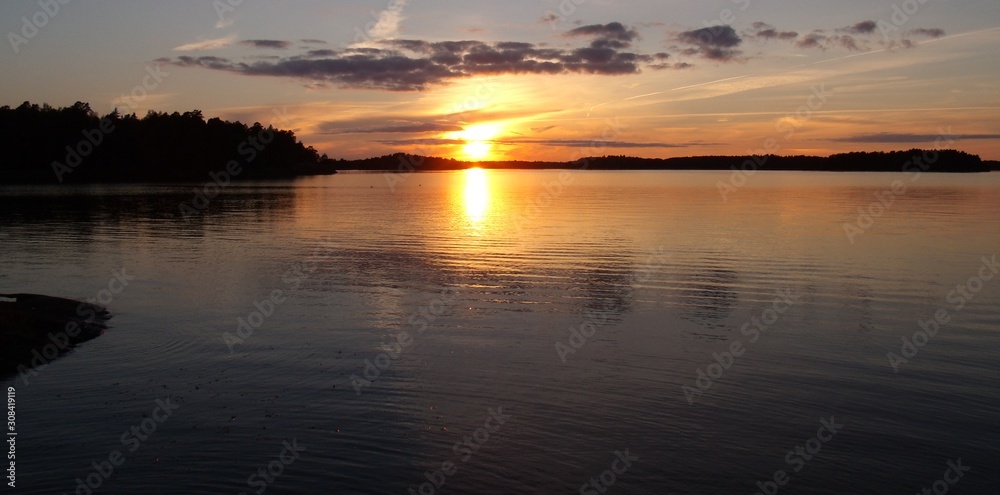 in the calm lake, the golden sunset is reflected