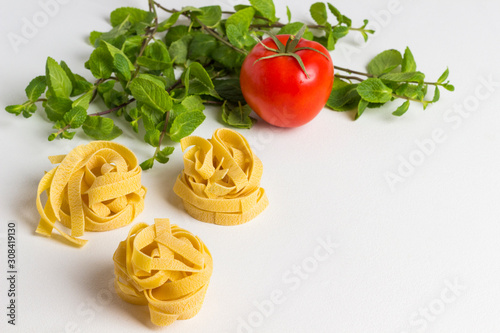 Durum wheat pasta on a white background. Tomatoes and mint.
