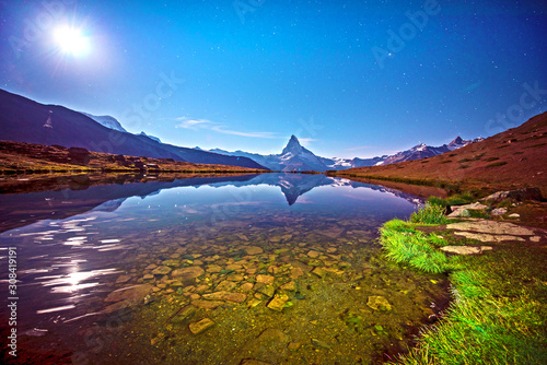 Fascinating landscape with  lake at star night with moon on the background the Matterhorn in the Swiss Alps and Lake Stellisee, near Zermatt, Switzerland, Amazing placec.  photo