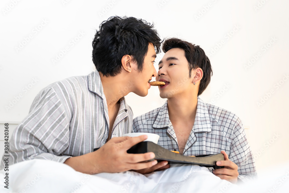Asian homosexual couple in pajamas having a breakfast in the bed.Concept LGBT gay. Asian homosexual couple in pajamas having a breakfast in the bed.Concept LGBT gay.
