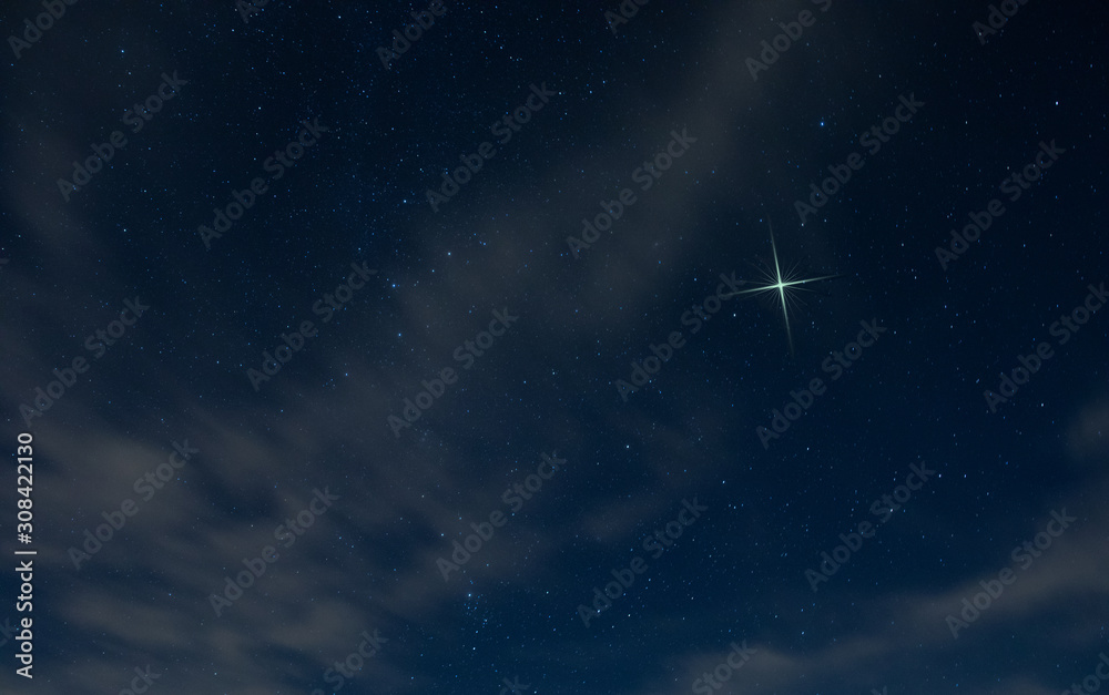 Christmas star rising in North Carolina with light clouds in the night sky.