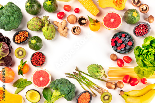 Vegan food. Healthy diet concept. Fruits, vegetables, pasta, nuts, legumes, mushrooms, shot from the top on a white background, forming a frame with a place for text. A flat lay composition