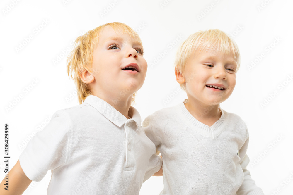 Two little caucasian brothers with blonde and fair red hair smiles, portrait isolated on white background Two little caucasian brothers with blonde and fair red hair smiles, portrait isolated on white background