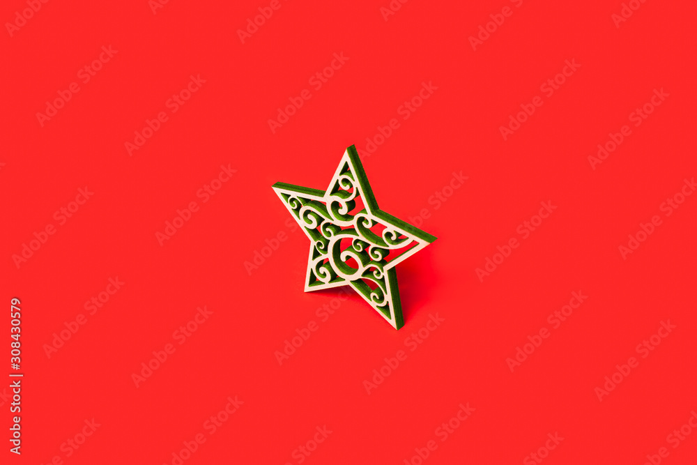 Decorative Christmas star made of wood with green patterns isolated on red background Decorative Christmas star made of wood with green patterns isolated on red background