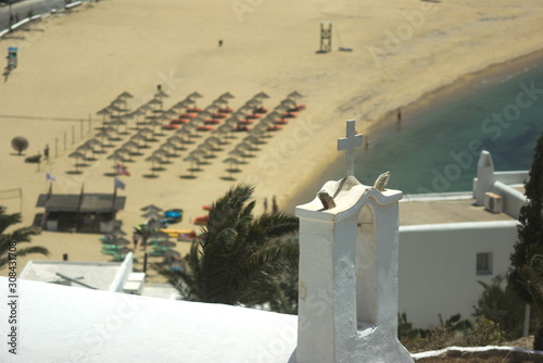 Ios island, Greece. View of Mylopotos beach from a hillside. chapels bell tower in the foreground.