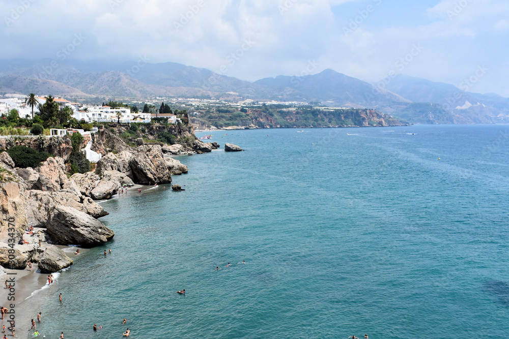 Nerja, Spain. Landscape view of the bay seen from the Balcon de Europa.  Cliffs and sea with mountains in the distance.  Copy space. 