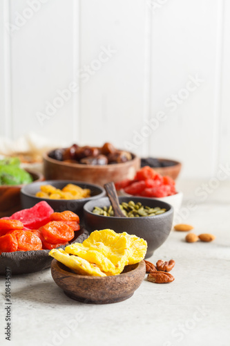Variety of dry fruits and nuts in bowls  copy space. Healthy food concept  white background.