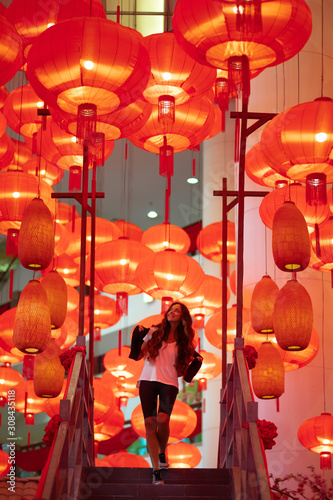 Happy admiring woman enjoying traditional red lanterns decorated for Chinese new year Chunjie. Cultural asian festival in Hong Kong.