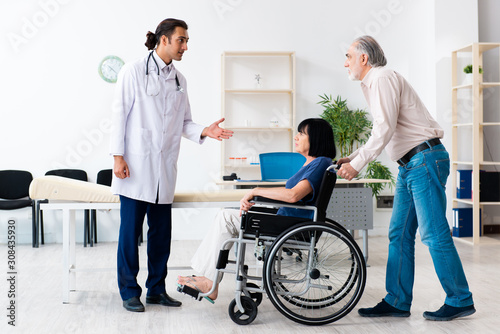 Old couple visiting young male doctor