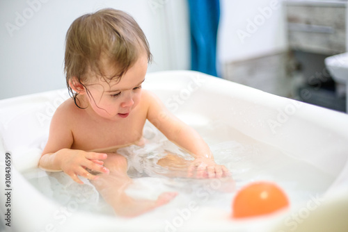 1 year old Baby in bathtub taking bath in bathroom