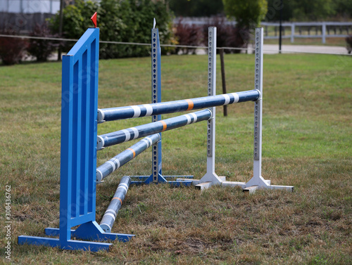 Colorful barriers on the ground for jumping horses and riders at riding school as a background.Obstacles for horses in a riding school