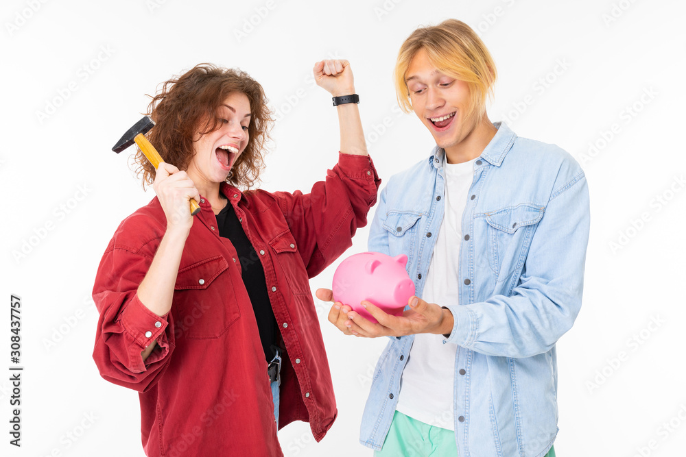 Stylish caucasian couple in love with pink pig moneybox isolated on white background Stylish caucasian couple in love with pink pig moneybox isolated on white background