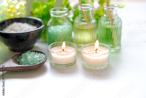 Thai Spa Treatments aroma therapy salt and nature green sugar scrub and rock massage with green orchid flower on wooden white with candle. Thailand. Healthy Concept.