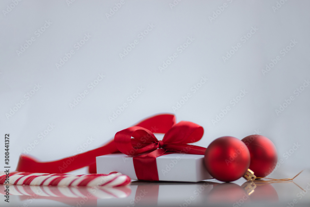 White gift box with red ribbon sweets and decorations on white background. Christmas and New Year holidays concept.