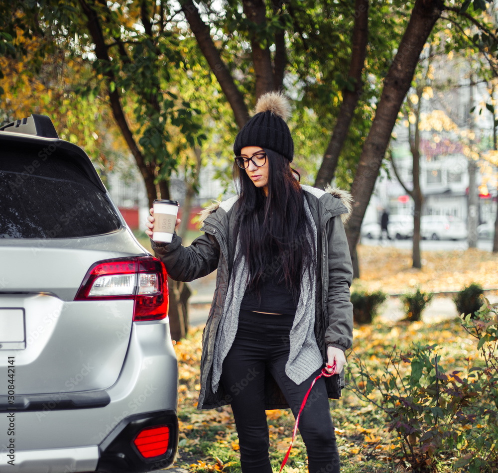 Young woman with puppy dog and coffee walking on street Young woman with puppy dog and coffee walking on street