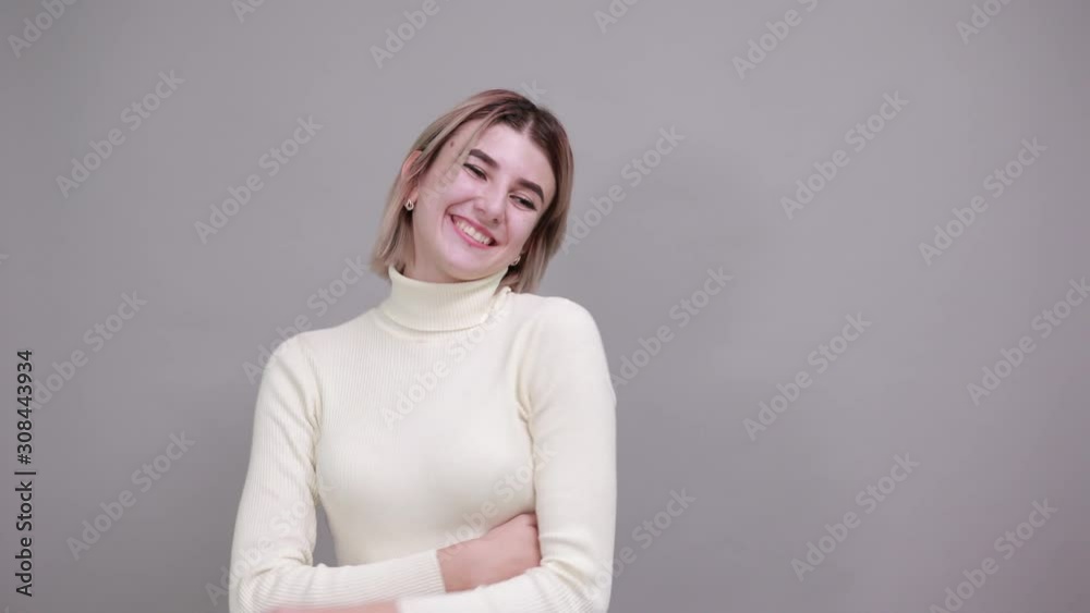 Young beautiful attractive caucasian woman keeping thumb up wearing pretty shirt on isolated gray background Young beautiful attractive caucasian woman keeping thumb up wearing pretty shirt on isolated gray background