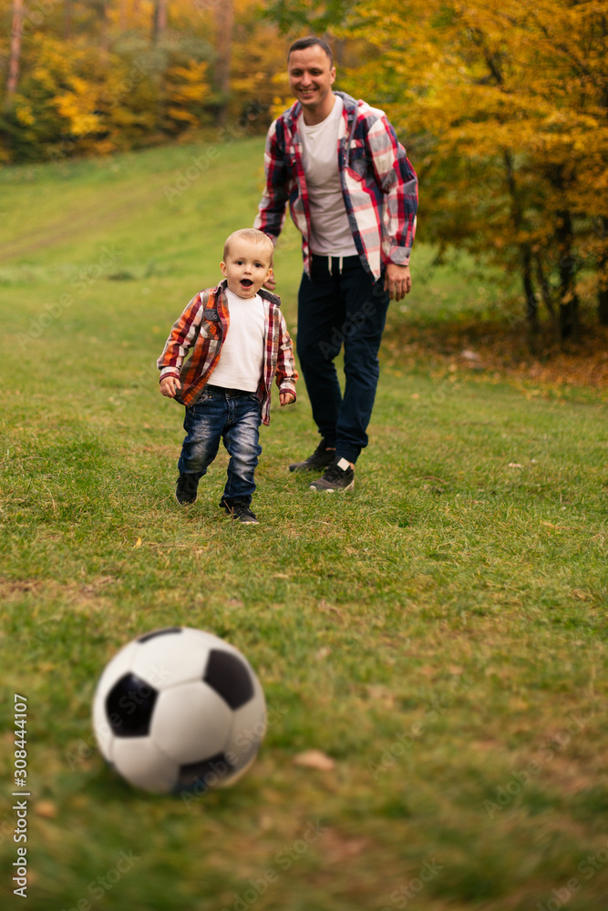 Son playing with ball on grass Son playing with ball on grass