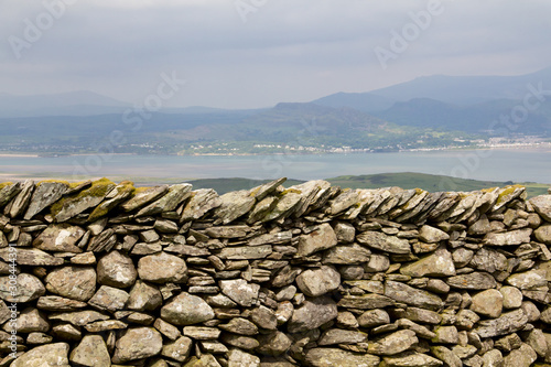 View over manmade stone wall towards the estuary at Harlech Wales UK.