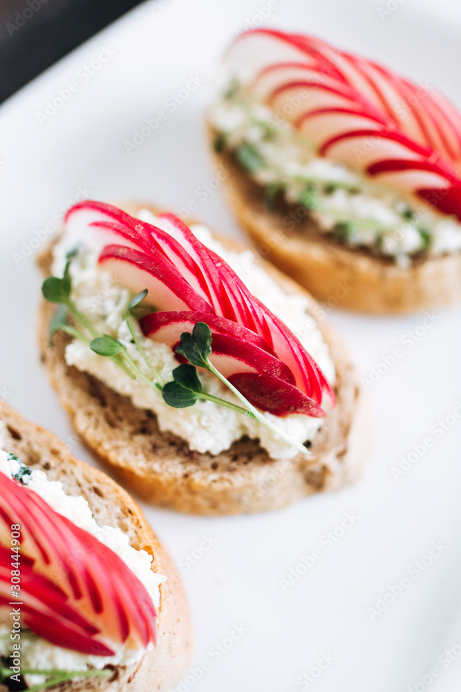 Canapes with cheese and garlic and radish, sprinkled with sprouts of young beans. Snack at the restaurant for alcohol Canapes with cheese and garlic and radish, sprinkled with sprouts of young beans. Snack at the restaurant for alcohol