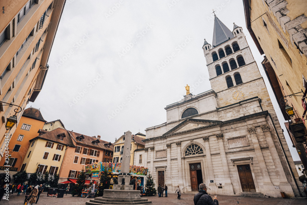 Annecy - France, 12.25.2018: Christmas, Xmas, New year, festivities near church. Photography of church and town square with old architecture.