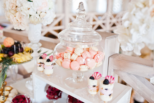 Dessert table of delicious sweets macaroons on wedding reception.