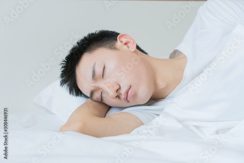 side view of bearded man sleeping on bed, lying on side