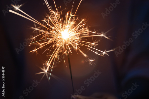 Hand of woman holding firework firework pyrotechnics and bokeh with blurry effect on the dark background for celebration concept