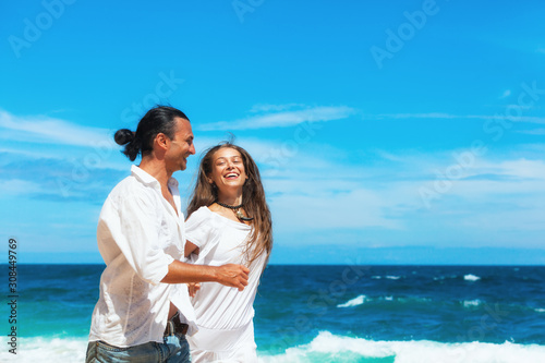 Happy family on honeymoon holiday - just married young couple having fun, run by water edge along sea beach surf. Active lifestyle, people recreational activity on summer vacation on tropical island. © Tropical studio