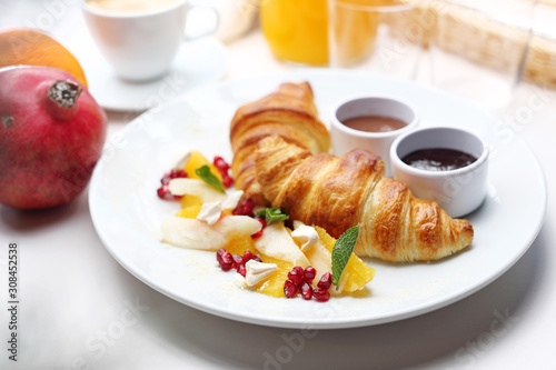Sweet breakfast, tasty fresh bread with toppings. Buttery croissant, chocolate, jam and fresh fruit salad.