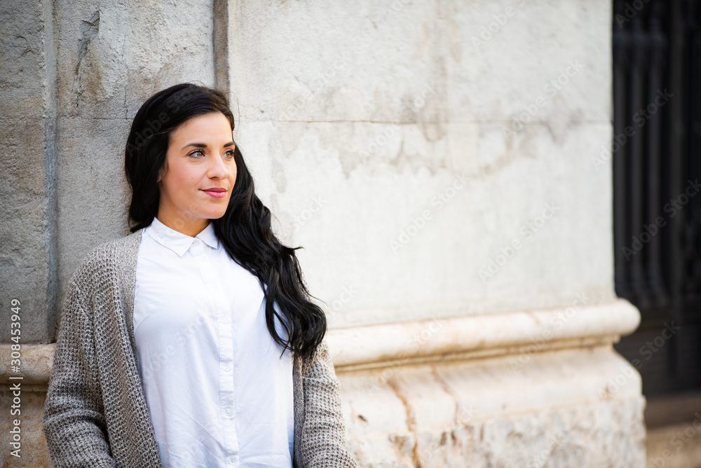 Young black long hair brunette woman resting in an urban scene. Young black long hair brunette woman resting in an urban scene.