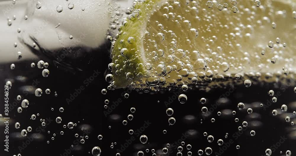 Lime ice and soda water bubbles turning close up