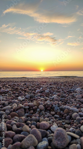 Beautiful Colorful Sunset Sunrise Landscape With Sand Beach, Golden Sun and Stones at Baltic Sea Shore in Latvia © Uldis