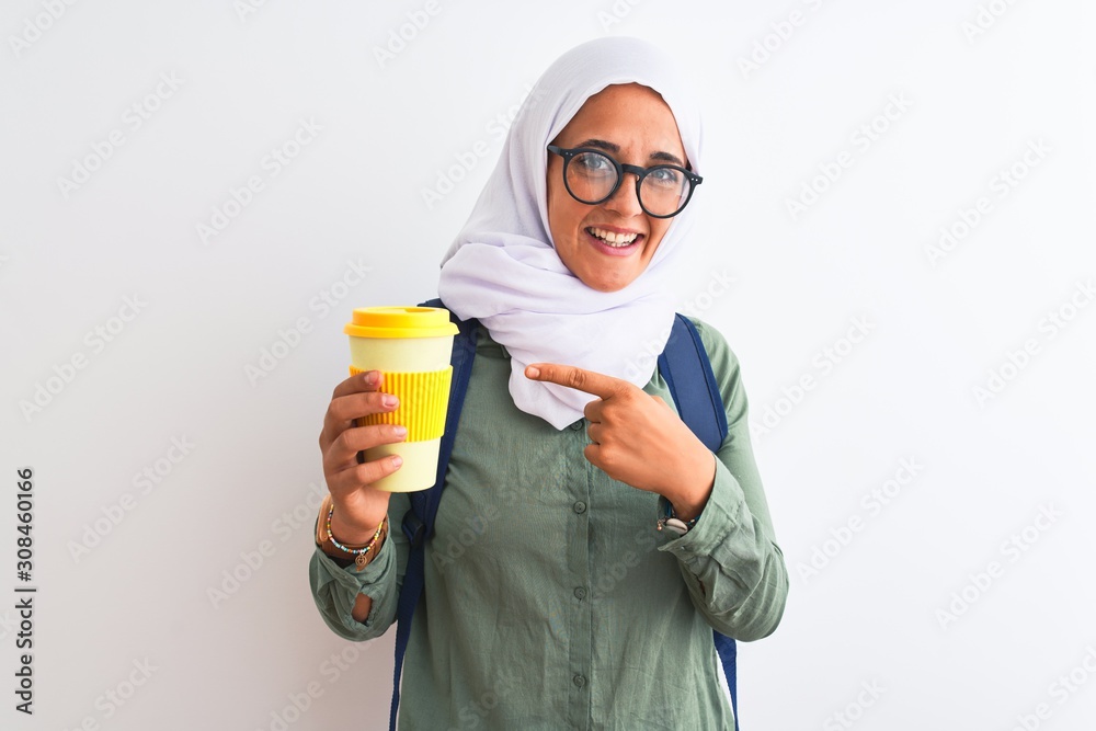 Young Arab student woman wearing hijab and drinking coffee over isolated background very happy pointing with hand and finger Young Arab student woman wearing hijab and drinking coffee over isolated background very happy pointing with hand and finger