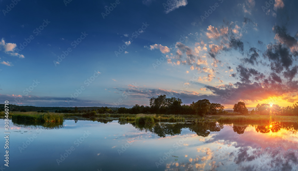 Beautiful sunset, sky with clouds above lake.
