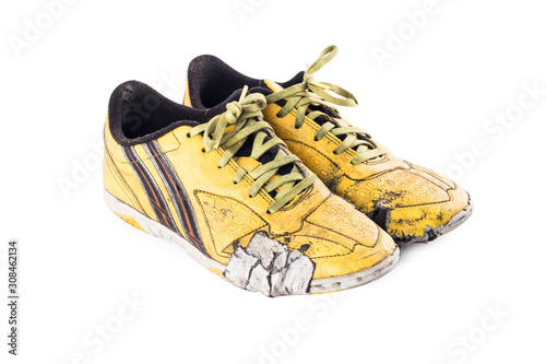 Old  worn out dirty yellow futsal sports shoes  on white background football sportware object isolated photo