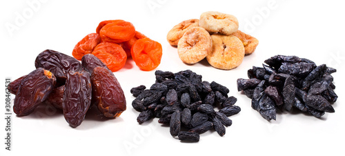 Heaps of dried fruits (fig, apricot, dates, raisins, prunes) isolated on a white background.