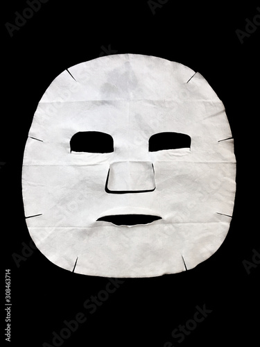 White facial sheet mask cosmetics on black background 
