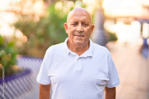 Senior handsome man smiling happy and confident. Standing with smile on face at town street