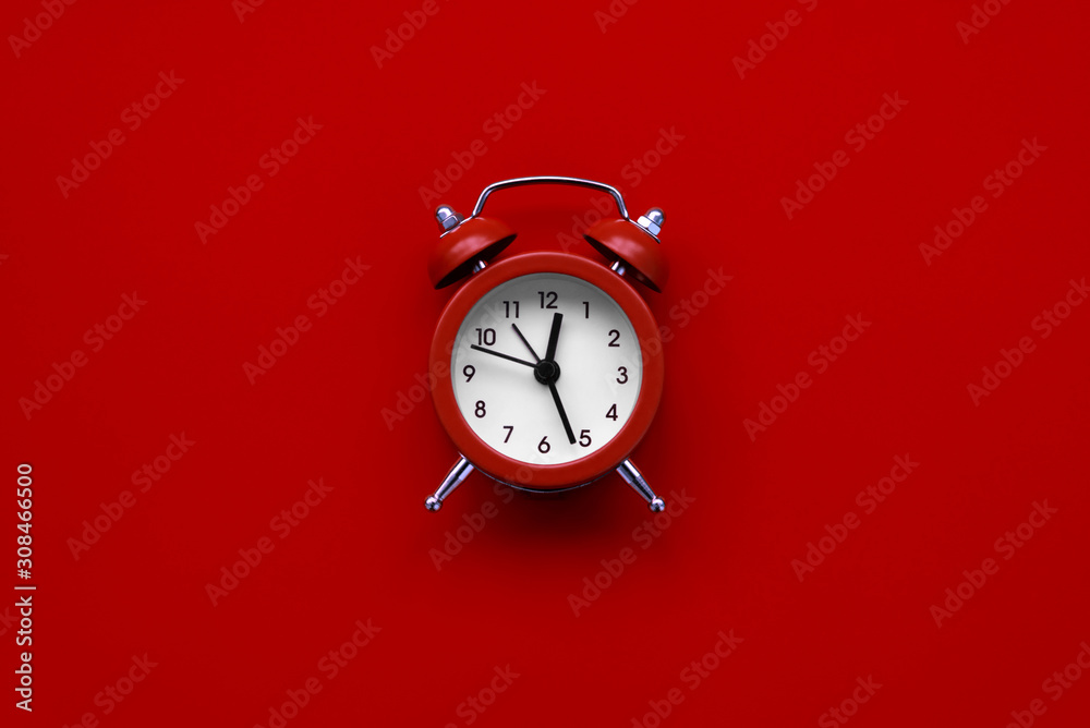 Alarm clock on red background. Top view. Flat lay Alarm clock on red background. Top view. Flat lay