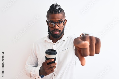 African american businessman with braids drinking coffee over isolated white background pointing with finger to the camera and to you, hand sign, positive and confident gesture from the front © Krakenimages.com