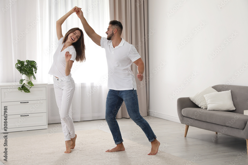 Obraz premium Lovely young couple dancing together at home