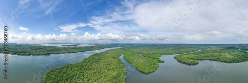 Aerial view the boat cross the river of green landscape  tropical mangroves and the river across in Sabah Borneo, Malaysia. Sustainable and biodiversity mangrove forest reserve.