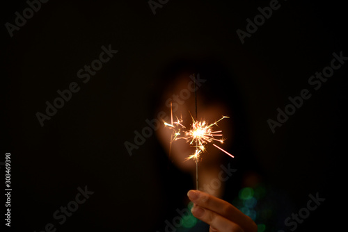 Girl holds sparkler in her hands