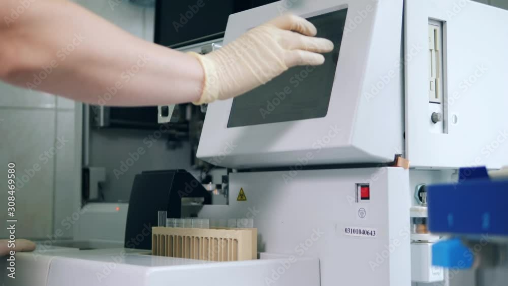 Lab expert is loading test tubes into the analyzer Lab expert is loading test tubes into the analyzer