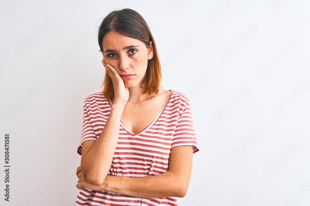 Beautiful redhead woman wearing casual striped red t-shirt over isolated background thinking looking tired and bored with depression problems with crossed arms. Beautiful redhead woman wearing casual striped red t-shirt over isolated background thinking looking tired and bored with depression problems with crossed arms.