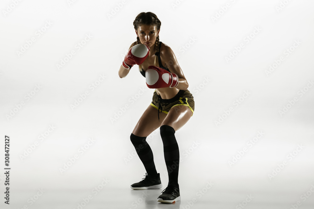 Fit caucasian woman in sportswear boxing isolated on white studio background. Novice female caucasian boxer training and practicing in motion and action. Sport, healthy lifestyle, movement concept. Fit caucasian woman in sportswear boxing isolated on white studio background. Novice female caucasian boxer training and practicing in motion and action. Sport, healthy lifestyle, movement concept.