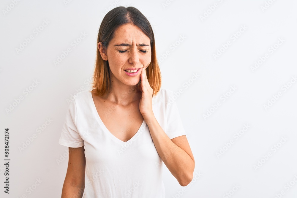 Beautiful redhead woman wearing casual white t-shirt over isolated background touching mouth with hand with painful expression because of toothache or dental illness on teeth. Dentist concept. Beautiful redhead woman wearing casual white t-shirt over isolated background touching mouth with hand with painful expression because of toothache or dental illness on teeth. Dentist concept.